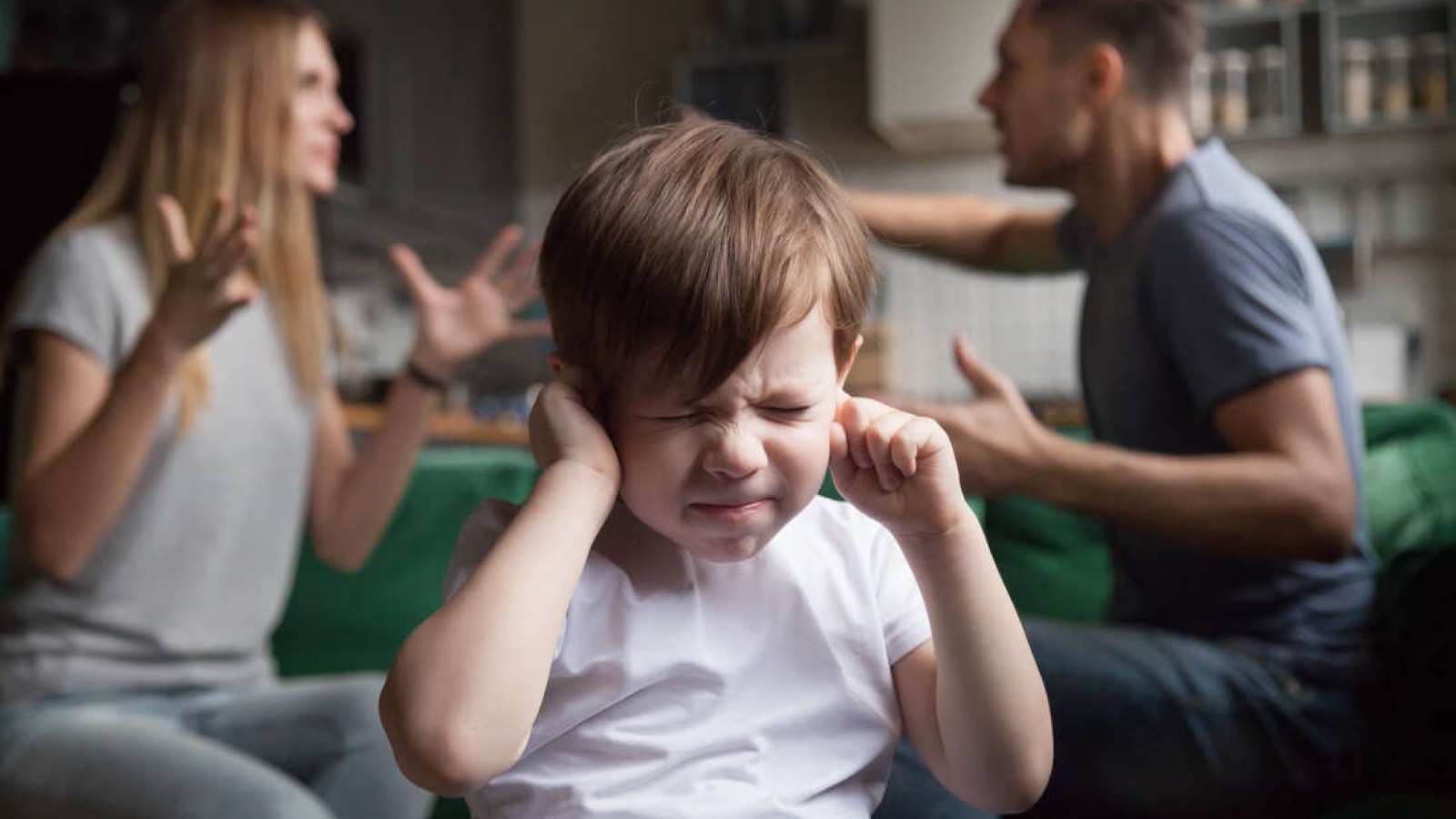 Frustrated kid son puts fingers in ears not listening to noisy parents arguing, stressed preschool boy suffering from mom and dad fighting shouting, family conflicts negative impact on child concept